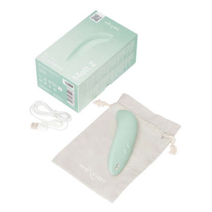 We-Vibe Melt 2 - Mint green electronic device with packaging, USB cable, and drawstring bag on a white background