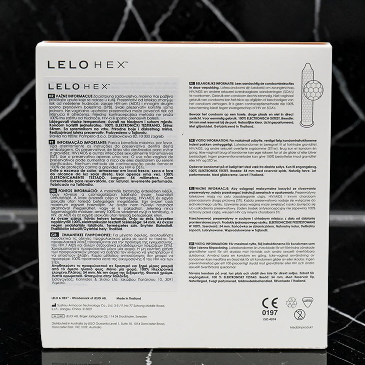 The back of a white LELO HEX box, featuring extensive product instructions in Portuguese and English, a product diagram, and certification logos, set against a dark textured background.