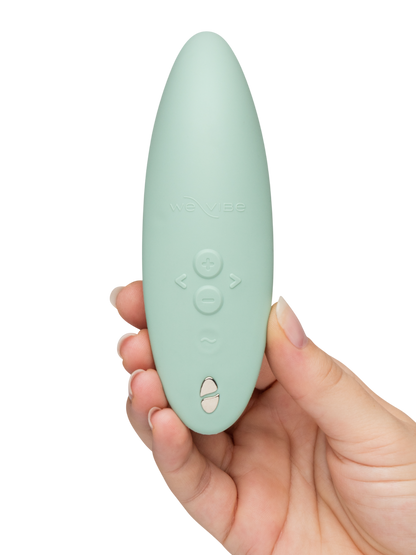 We-Vibe Melt 2 - Mint green remote control held in a hand against a white background