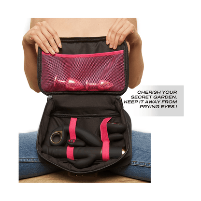 Black toiletry bag with pink accents held open by a person, showing items inside.